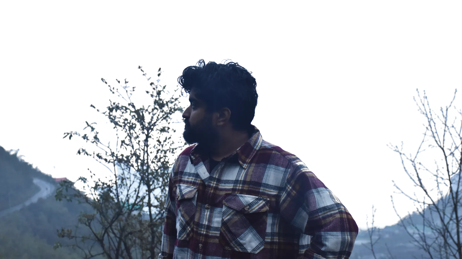 Saptarshi Chattopadhyay on a misty hillside, looking away from the camera